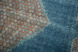 Distressed vintage Mahal rug: red floral pattern, stepped contour, and watery blue field.