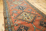 Vintage Heriz rug detail: terra cotta field with blue geometric medallions and pinwheels.