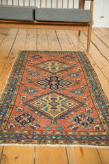 Vintage hand-knotted Heriz runner detail: pinwheel and floral cross-section patterns, terra cotta, navy blue.