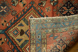 Folded vintage Heriz rug showing hand knotted construction, pile texture, and geometric back pattern.