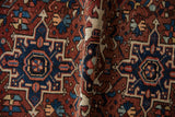 Sharp contoured geometric motifs in brick red, navy, and ivory on traditional Karaja rug.
