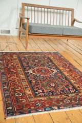 Vintage Karaja rug showing bold geometric field with radiating navy, cherry red, and ivory patterns.