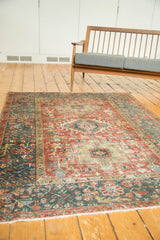 Distressed vintage Karaja rug, wide teal border with evolved floral vinery, red field.