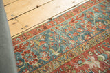 Distressed vintage Karaja rug with intricate floral patterns, cherry red, sky blue, and wear.