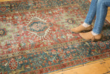 Distressed vintage Karaja rug's wide teal border, floral vinery, and stylized red field.