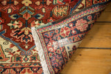 Folded Heriz rug corner showcasing ivory fringe, intact selvage, and classic geometric motifs.
