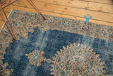 Distressed blue pile with subtle ivory and blush motifs on the vintage Sparta rug.