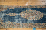 Distressed texture of sky blue field and European floral border in antique ivory.