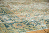Distressed vintage Mahal carpet corner, highlighting worn teal and pale orange floral border.