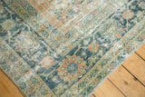 Distressed Mahal rug corner, showing terra cotta Herati field and teal floral border.