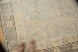 Textured pile of a vintage distressed Khotan carpet, with geometric vinery in muted silver and blush.