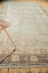 Vintage Distressed Khotan carpet's geometric vinery pattern in soft silver and blush hues.