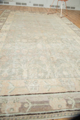 Distressed vintage Khotan carpet border with faded blush and ivory geometric patterns.