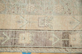 Distressed Khotan carpet border with faded geometric vinery in silver, blush, and ivory tones.
