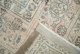 Distressed Sivas carpet corner shows worn blush and ivory pile with hand-knotted back.