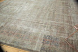 Distressed Sivas square carpet texture showing faded Herati motif, blush, silver, and visible foundation.