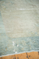 Distressed Peking carpet, showing textured low pile and exposed foundation in ivory and sea foam.
