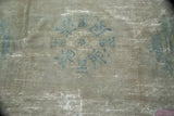 Distressed pile and foundation of an antique Peking carpet with faded blue symbolic imagery.