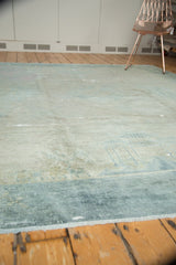 Distressed wide border of antique Peking rug showing soft blue tones, low pile.