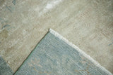 Corner of distressed Peking carpet, showing worn pile, sea foam blue backing, and white fringe.
