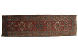 Distressed vintage Karaja runner rug with single column medallions in burgundy, teal, and ivory.