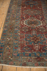 Distressed vintage Karaja runner's low pile, highlighting rich burgundy and teal geometric border.
