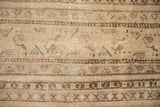 Intricate boteh pattern on vintage hand-knotted Mir Sarouk rug; sandy tones, brown bands, and even wear.