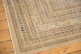 Fringed corner detail of vintage Mir Sarouk carpet, with visible wear and muted blue accents.
