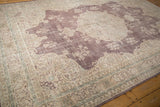 Traditional distressed Sivas carpet showing plum field and beige floral border.