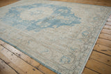 Distressed Sparta carpet corner showing softened sky blue and ivory hues with visible foundation.