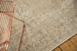 Softened beige and charcoal European scrolling vinery on a distressed vintage Sparta carpet.