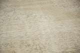 Faded texture and subtle scrolling vinery on the distressed Sparta carpet in beige and sand tones.