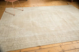 Corner view of a vintage Distressed Sparta rug showing beige and ivory European scrolling vinery.