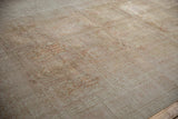 Textured surface of distressed vintage Kashmir silk carpet, showing faded multi-paneled designs.