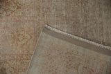 Hand-knotted Kashmir Silk rug showing distressed pile, visible foundation, pale pink patterns.