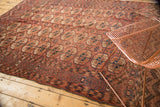 Corner of antique Turkmen carpet with madder red field and unique plant-pomegranate border.