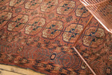 Antique Turkmen carpet main border featuring germinating plant motifs in madder red and navy.