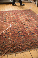 Diagonal view of antique Turkmen Bokhara carpet, madder red guls and pomegranate-inspired end border.