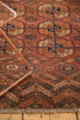 End border of antique Turkmen rug, featuring madder red, navy, and ivory pomegranate motifs.
