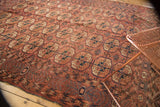 Antique Turkmen carpet showing madder red Bokhara guls with navy accents and unique border.