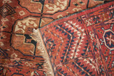 Detail of hand-knotted antique Turkmen rug, showing low pile, knot heads, madder red fringe.
