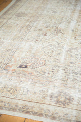 Distressed vintage Sivas carpet texture with ivory, beige, and brown tones, showing wear to knot heads.