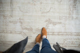 Distressed vintage Sparta carpet showing soft ivory tones, faint foundation, and rococo designs.