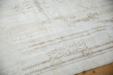 Distressed Sparta carpet showing even wear, antique ivory tones, and faint rococo style designs.