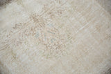 Distressed vintage Sparta carpet with even wear, revealing faint rococo style outlines.