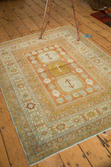 Distressed vintage Northwest Persian rug corner with Laleh Abassi pawn design in terra cotta, gold, and blue.