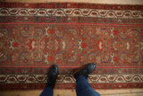 Scale and texture of an antique Malayer rug runner with a bronze Herati-motif field and brick red borders.