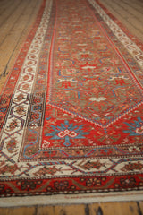 View down the length of an antique Malayer runner, detailing the low pile and complex border design.