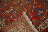 Folded corner of an antique Persian Malayer rug showing its hand-knotted foundation and pile.