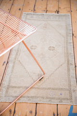 Faded ivory and platinum geometric motifs on a distressed vintage Oushak rug with subtle blue flecks.